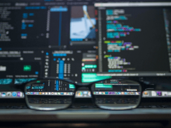 Image of eyglasses in front of screens with code